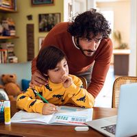 Father helping his son with his homework. Parent child student little boy