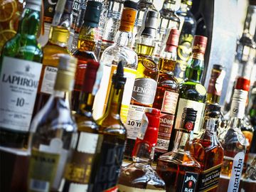 Several types of bottled alcohol are displayed on some shelves in a pub in Bucharest, Romania.