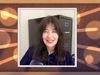 A photo of Joy Harjo, a woman with long dark hair, framed by a stylized border with a wood grain and light streaks.
