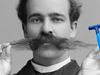 A black-and-white photo of a white man from the late 19th century wearing an extremely long mustache. Cut-out hands hold a blue razor to the right side of the image.