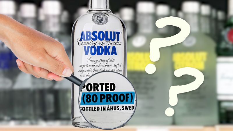 A hand holds a magnifying glass over an Absolut Vodka label, highlighting “80 PROOF” with question marks in the background.